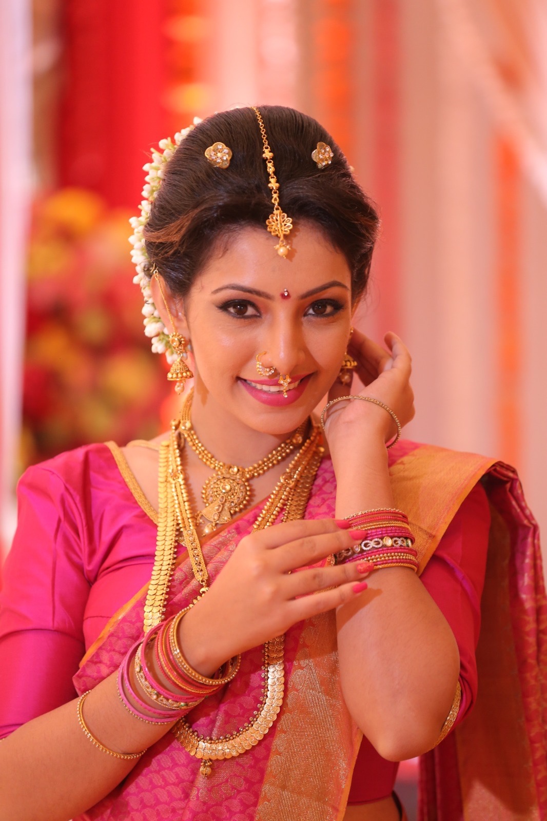 Bride in a vivid pink sari with polished hair and makeup